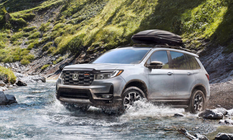 2022 Honda Passport driving in a stream with clamshell top